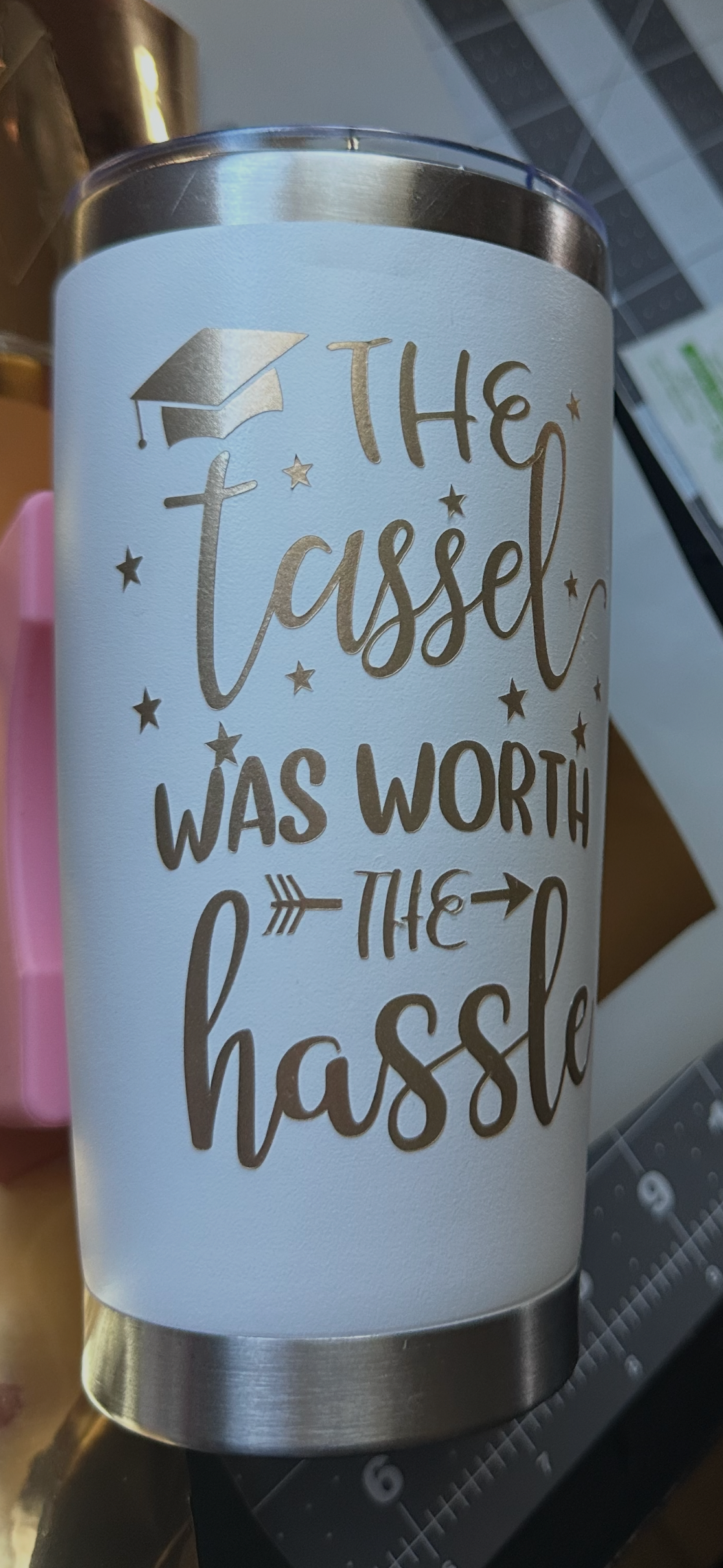 White 20oz stainless steel tumbler laser engraved in gold with The Tassel Was Worth the Hassle graduation cap and stars design