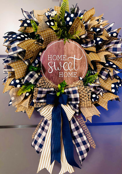 Handmade Home Sweet Home wreath with navy blue and gold mesh, buffalo check bow, and decorative berries.