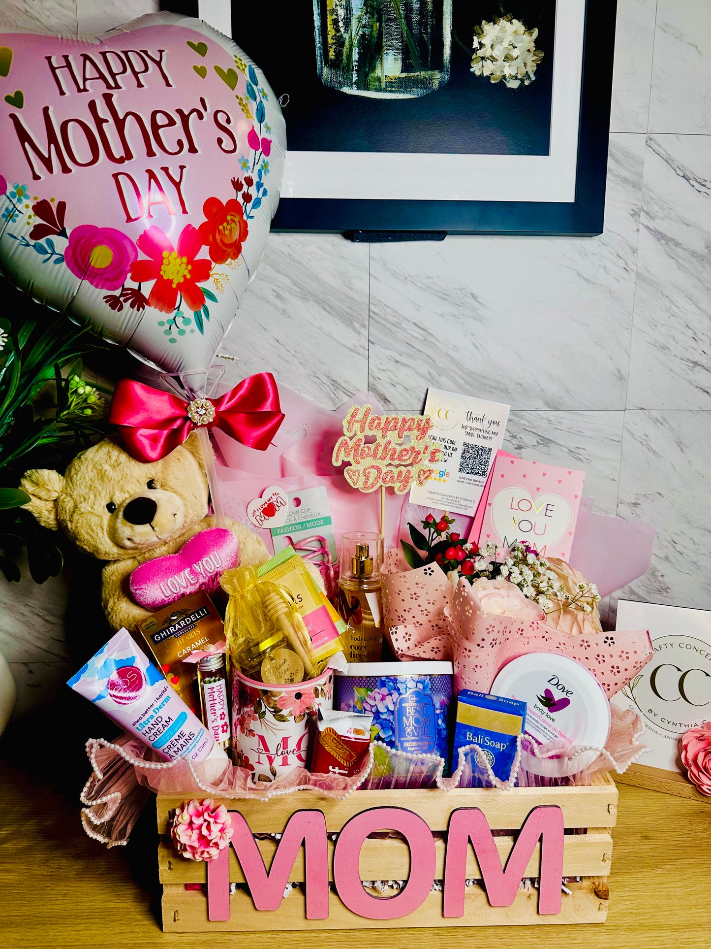 Luxury Mother’s Day gift basket with candle, body care, perfume mist, fuzzy socks, soap, and floral decor in wooden crate for mom.