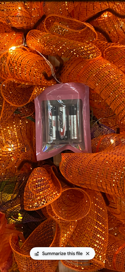 Back of fall LED wreath showing the discreet battery pack tucked into orange deco mesh, batteries included