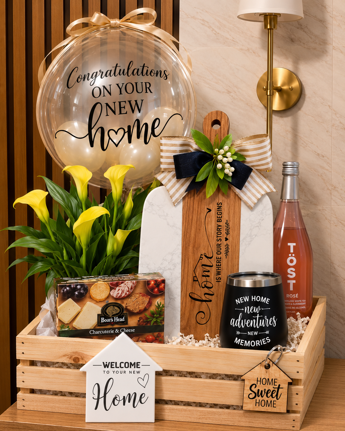 Deluxe new home gift basket in a wooden crate with congratulations balloon, engraved marble charcuterie board, wine tumbler, gourmet cheese, sparkling rosé, and yellow calla lilies — housewarming and realtor closing gift by Crafty Concepts.