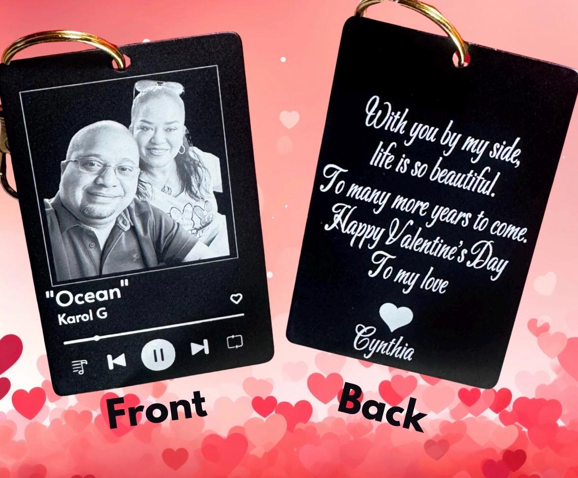 A personalized music plaque keychain in matte black with a custom couple's photo and song title, paired with a white insulated travel mug that says 'Coffee is my Valentine' and a box of chocolates