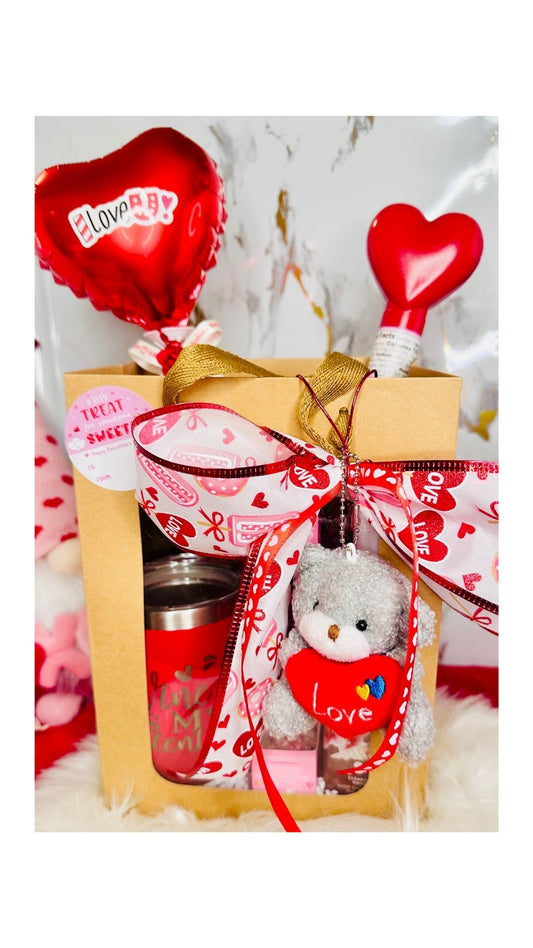 Valentine's Day gift set in a window gift bag featuring a coffee mug tumbler, plush bear, Lindt chocolate truffles, and Bath & Body Works soap.