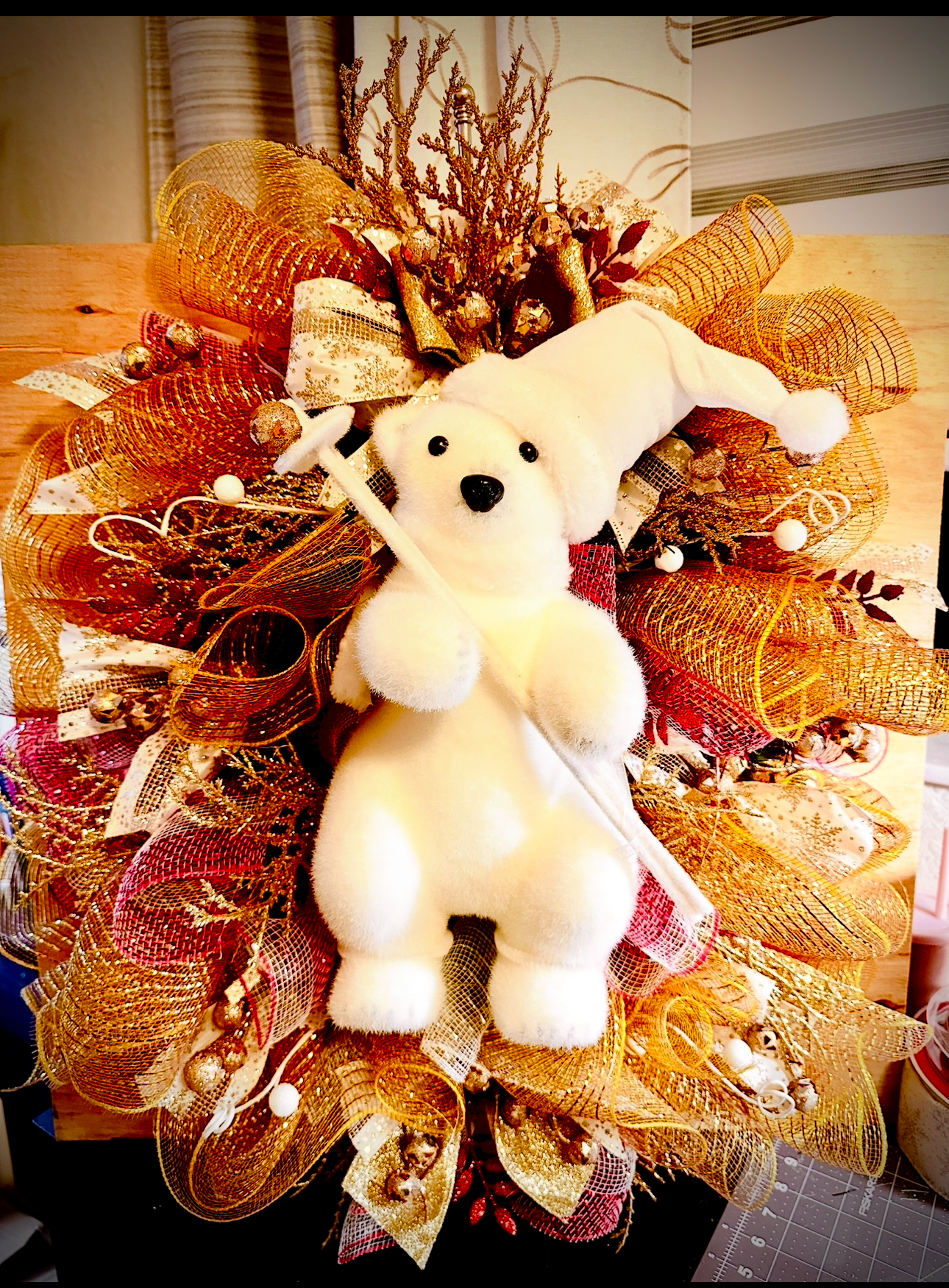 Handmade polar bear Christmas wreath with snowy greenery.