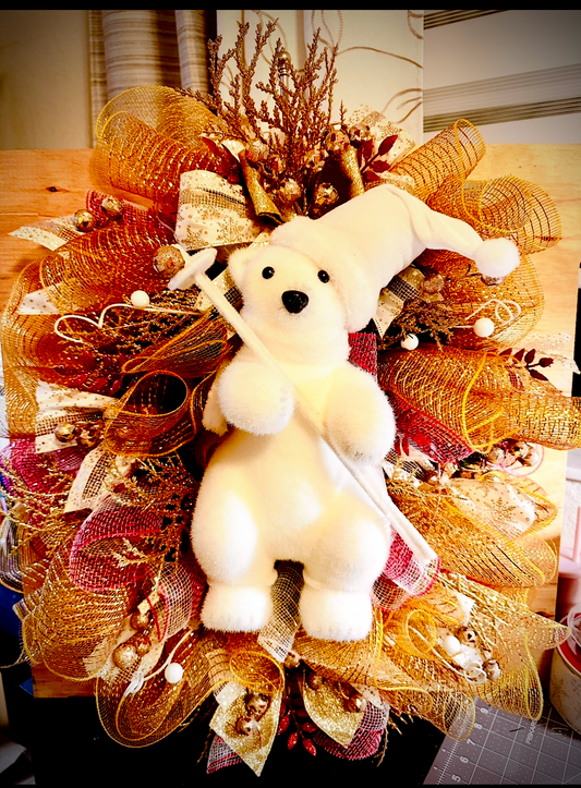 Handmade polar bear Christmas wreath with snowy greenery.
